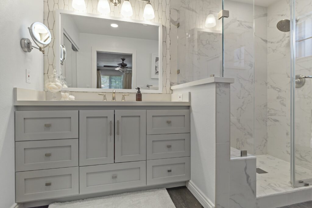 Mission Viejo bathroom remodel featuring shaker vanity with integrated drawers, quartz countertop, and walk-in marble tile shower