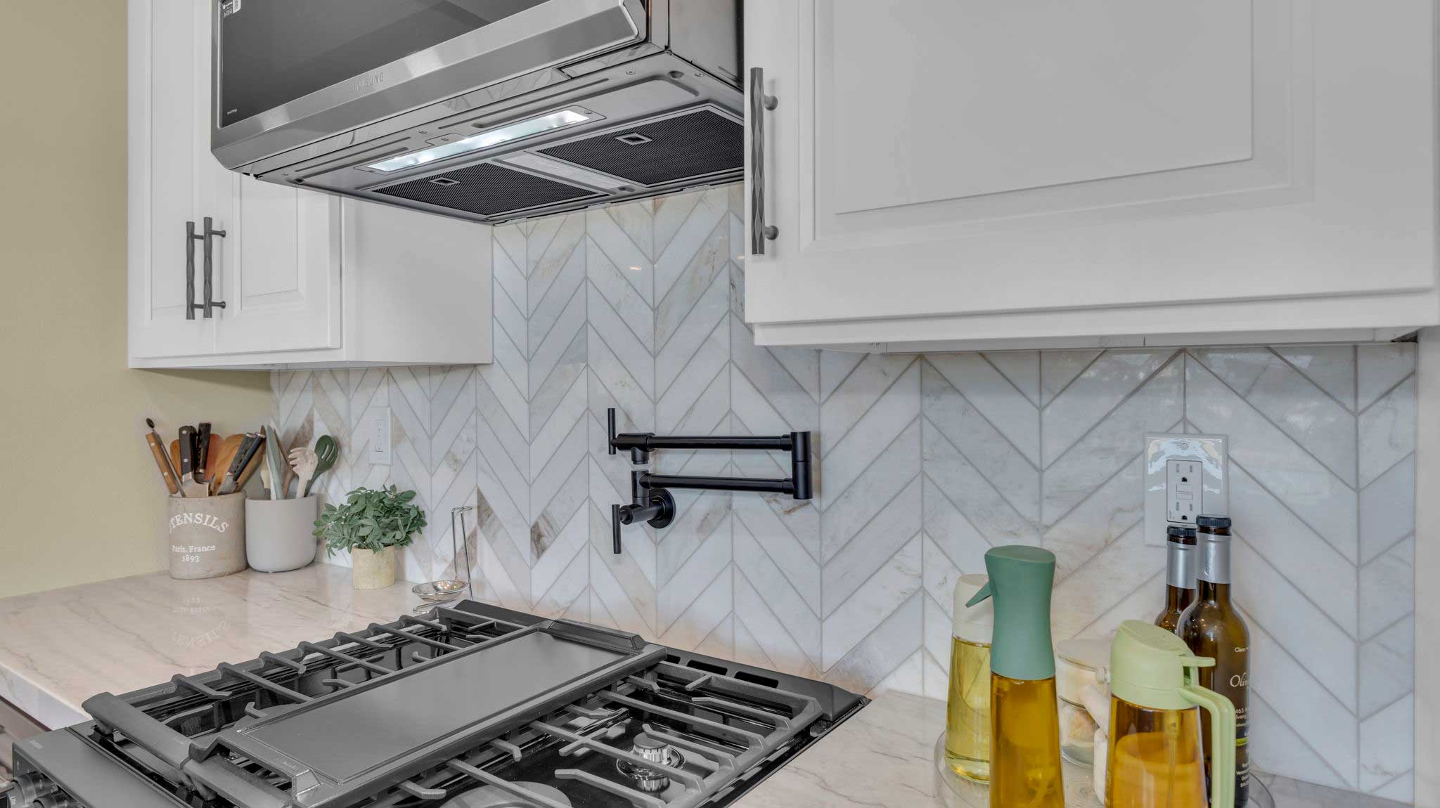 Chevron marble backsplash with pot filler in modern kitchen remodel