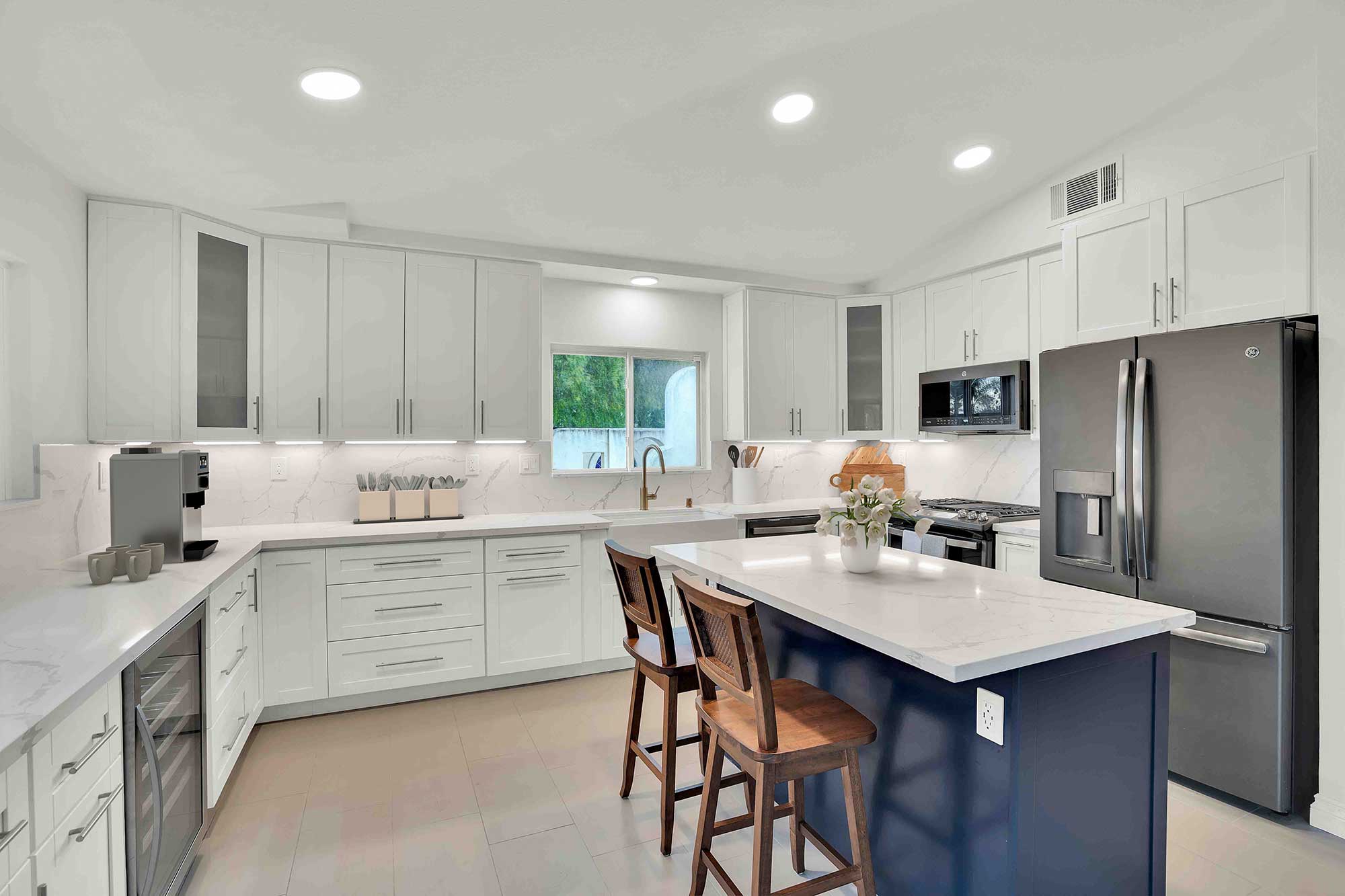 Oceanside kitchen with white shaker cabinetry, island and pendant lighting