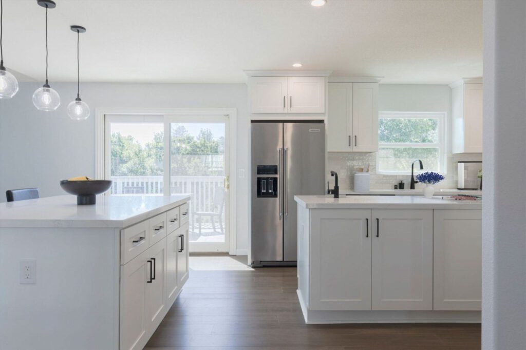 Modern white kitchen with sliding door to outdoor deck in Newport Beach