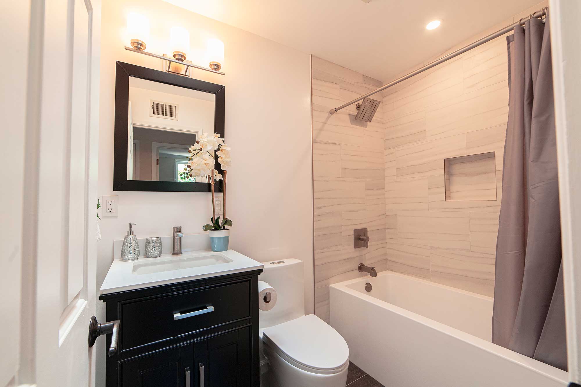 Irvine bathroom remodel with dark vanity a tub-shower combo