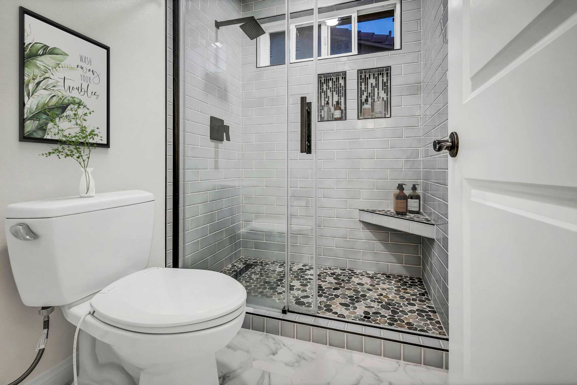 San-Clemente bathroom remodel with walk in shower and pebble tile floor