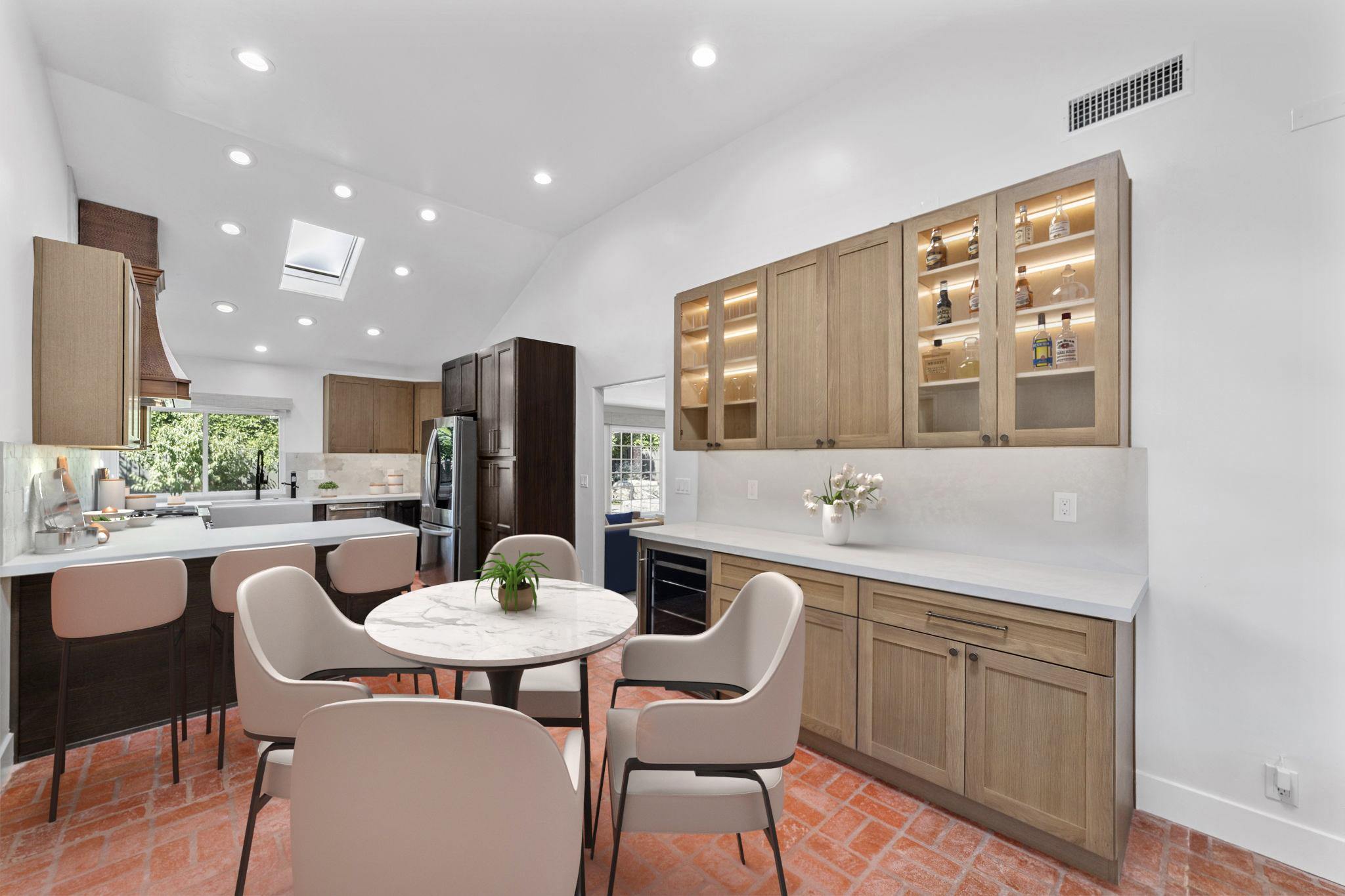 Modern Orange County kitchen featuring natural wood cabinetry, light quartz countertops, glass-front cabinets with interior lighting, and a bright open-concept layout.