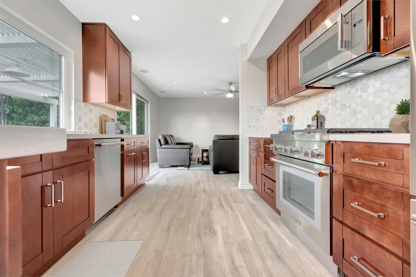 Mission Viejo kitchen remodel - Cherry wood galley kitchen, geometric backsplash, farmhouse sink, pro-style range