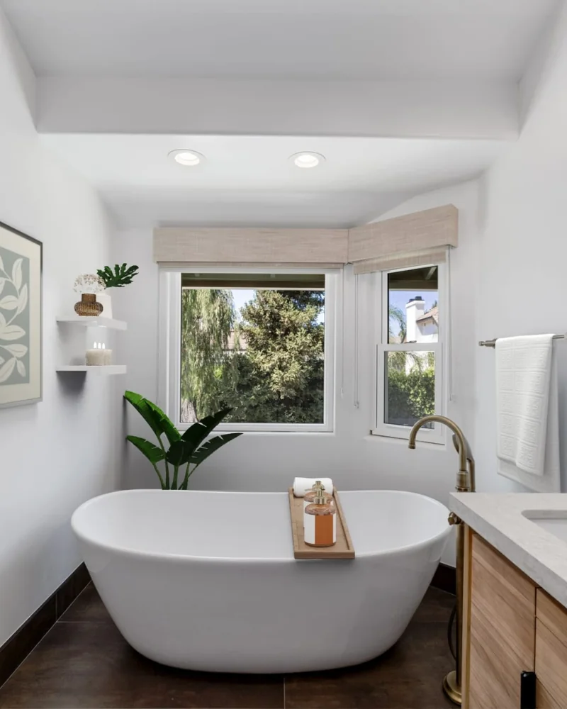 Modern bathroom remodel with freestanding tub and wood vanity