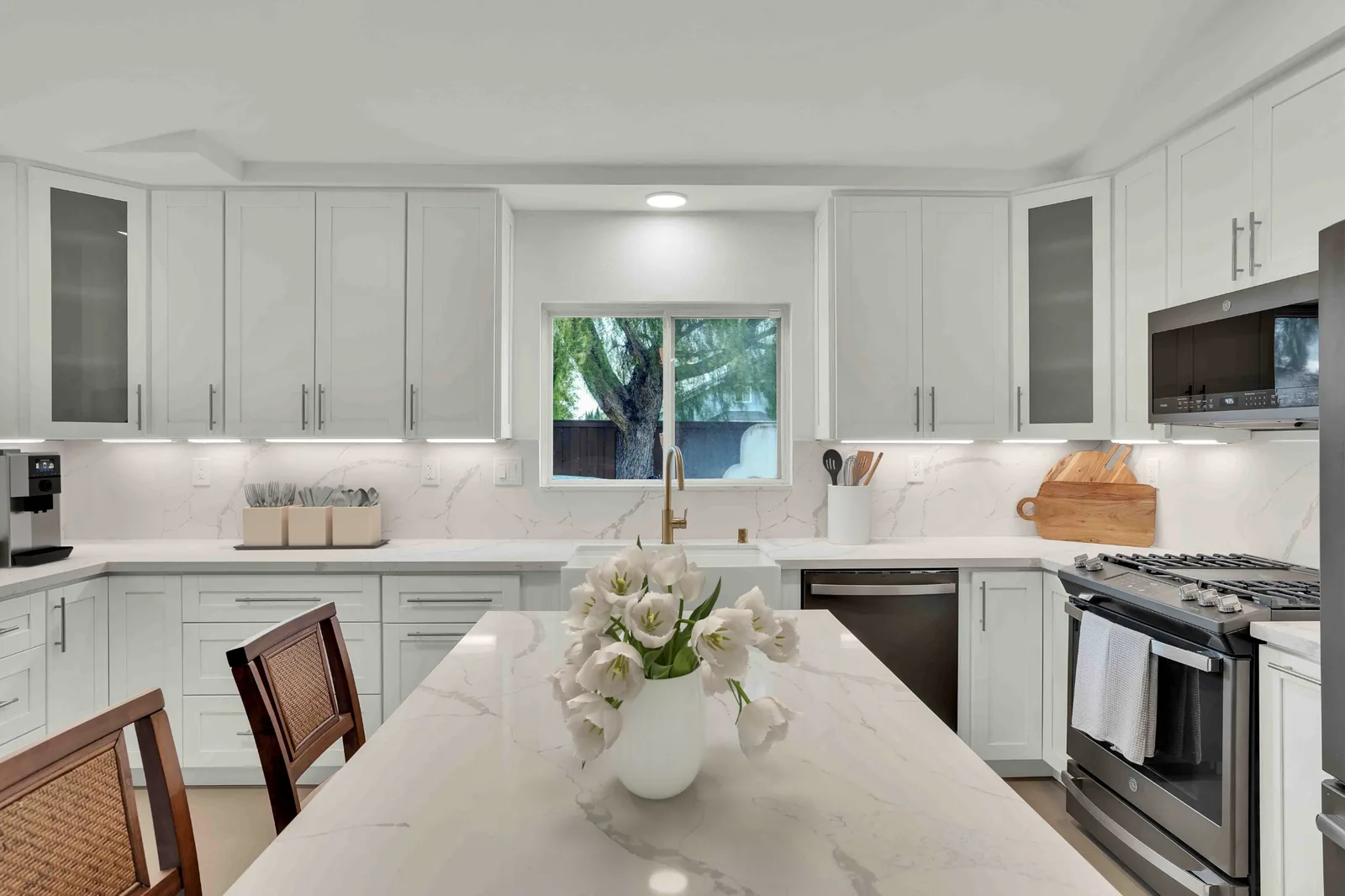 Oceanside kitchen remodel - White shaker cabinets, calacatta quartz backsplash, gold fixtures, farmhouse sink