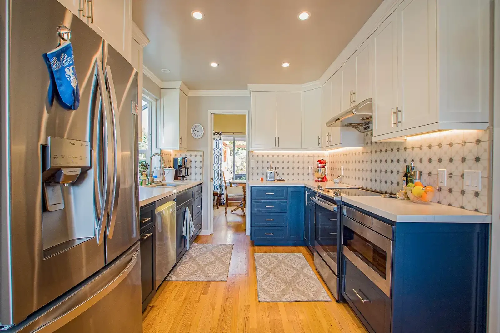 Laguna Niguel kitchen remodel - Two-tone blue and white cabinets, star-pattern tile backsplash, hardwood floors