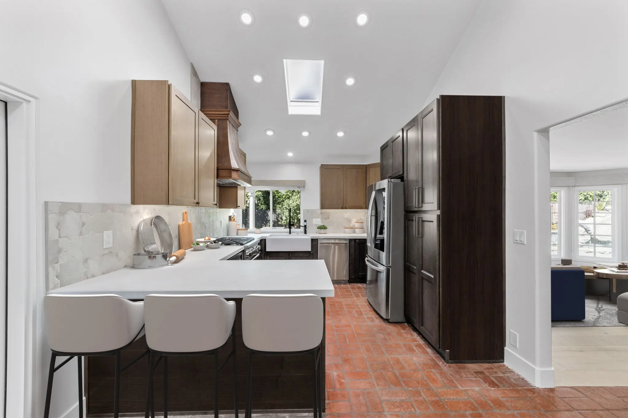 After kitchen remodel in Santa Ana with two-tone cabinets, quartz countertops, farmhouse sink, and open layout