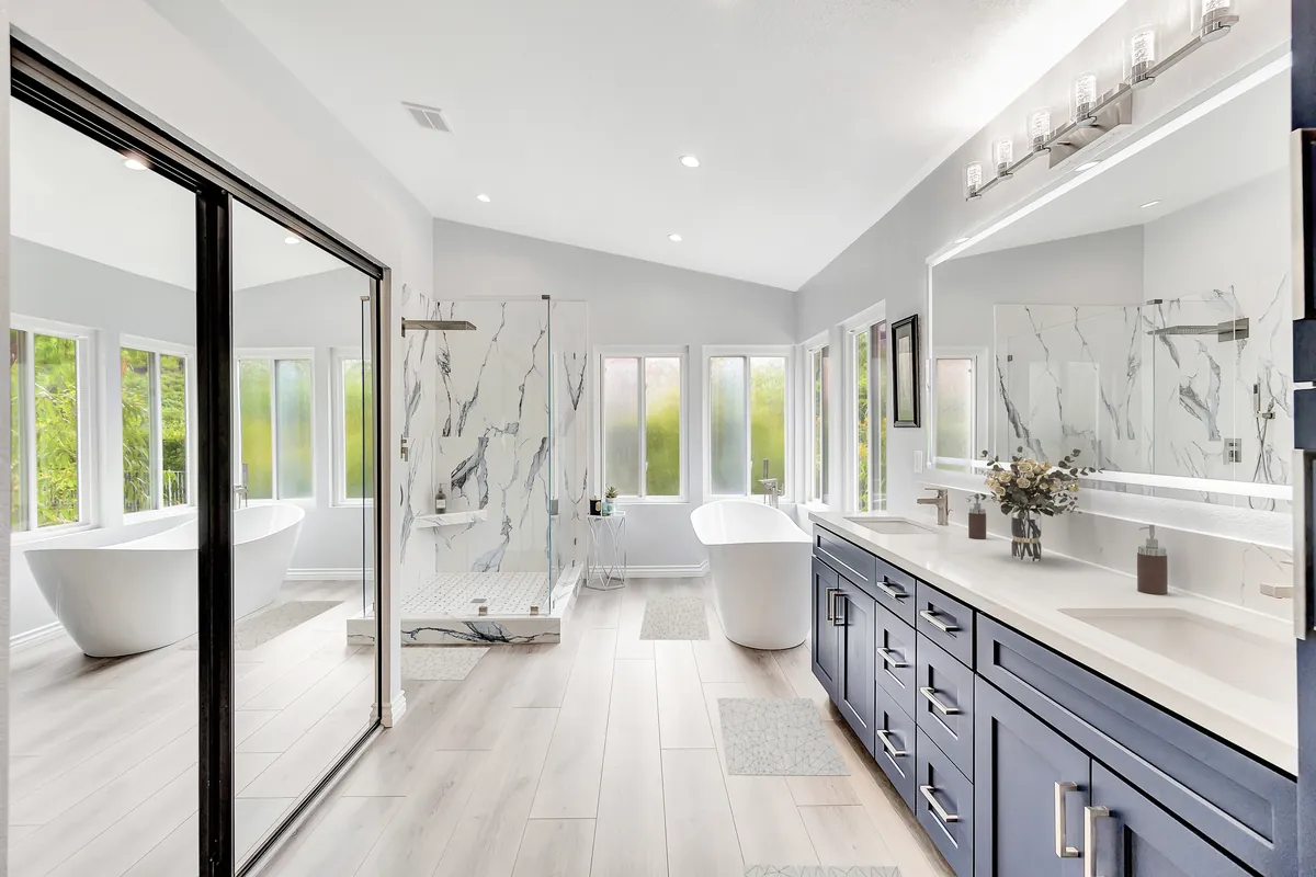 San Juan Capistrano master bathroom project — a freestanding soaker tub beneath frosted garden-view windows