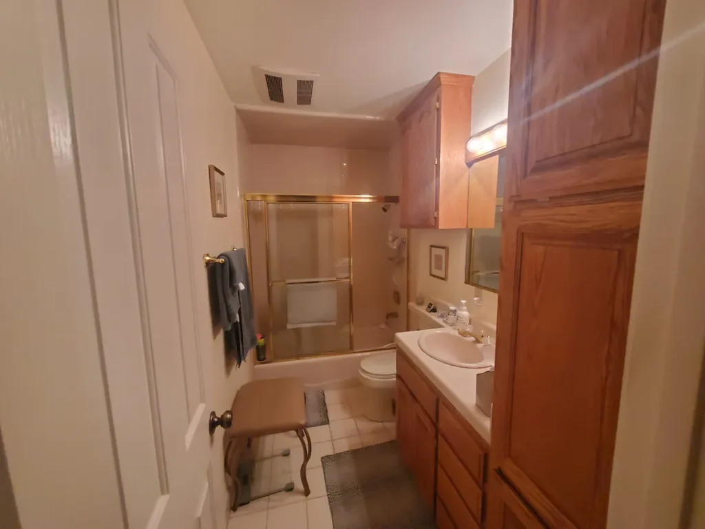 San Juan Capistrano guest bathroom before remodel with wood-stained cabinetry, dated layout, and older fixtures