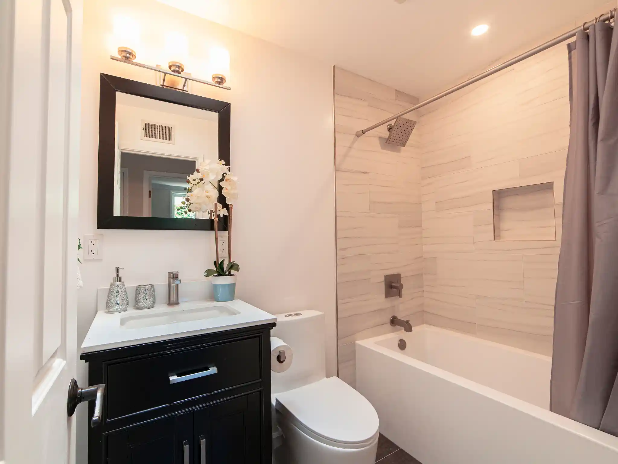 Irvine bathroom remodel with black vanity and tub shower
