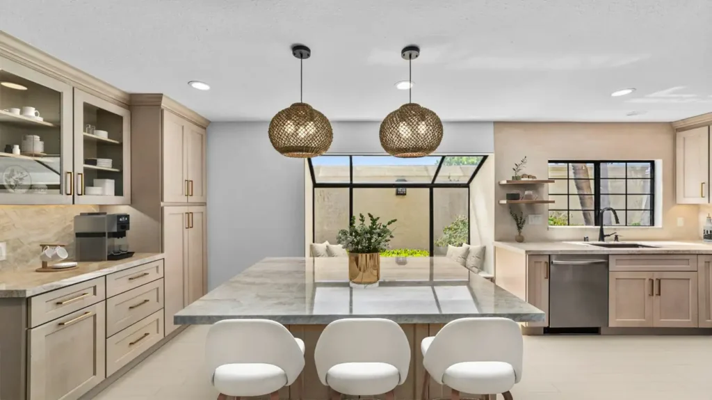 Large stone island with woven pendant lights in a finished kitchen remodel in Carlsbad.