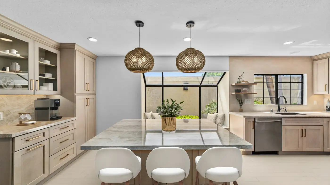 Large stone island with woven pendant lights in a finished kitchen remodel in Carlsbad.