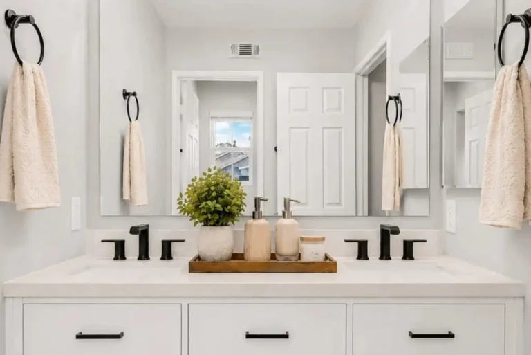 After photo of a remodeled Placentia bathroom with a white double vanity, matte black fixtures, and quartz countertop