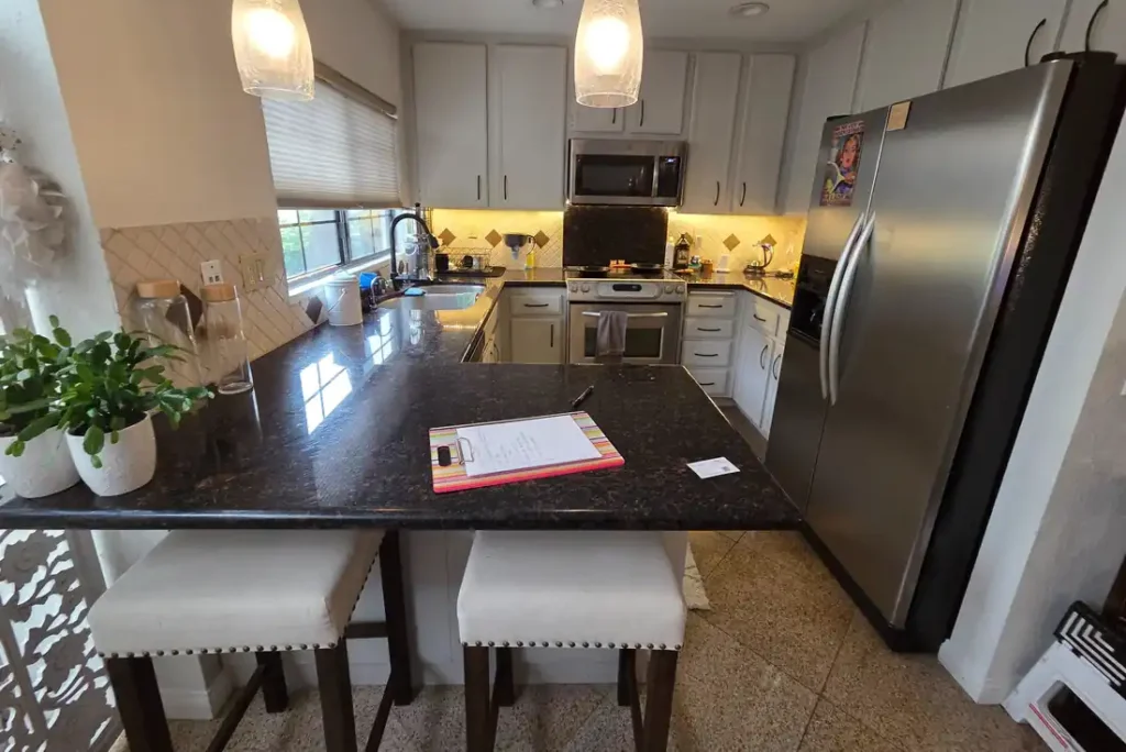 Original Carlsbad kitchen with dark granite countertops before remodeling