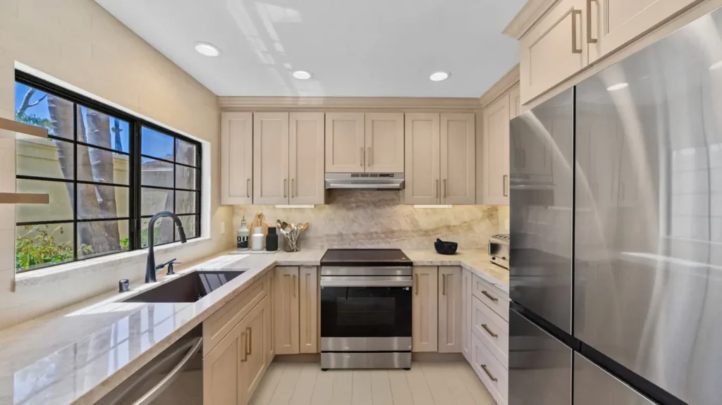 Stainless steel range and refrigerator with light wood cabinets in a remodeled kitchen in Carlsbad.