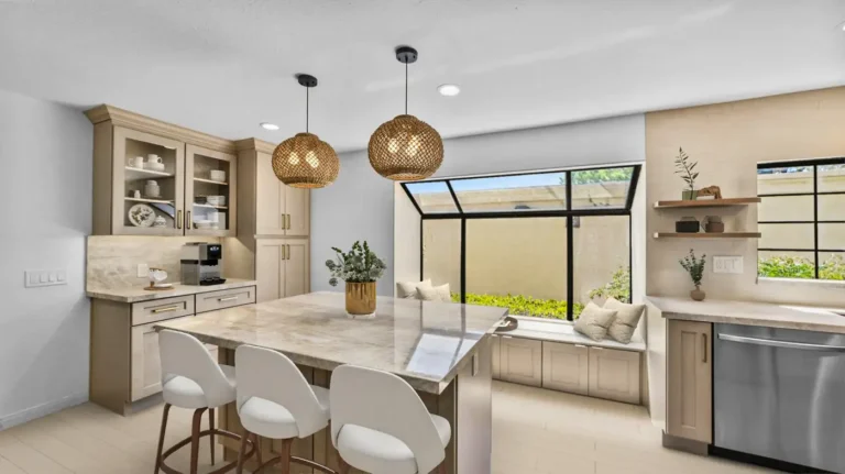 Large stone island with a built-in coffee station and window seat in a Carlsbad kitchen remodel.