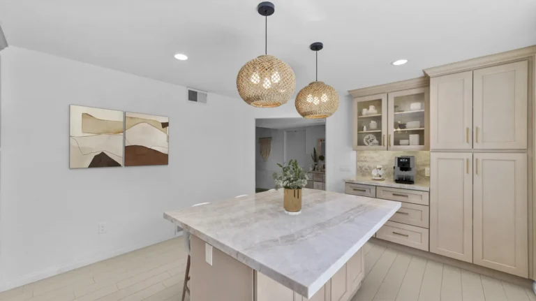 Stone island and full-height pantry cabinets in a bright finished kitchen remodel in Carlsbad.