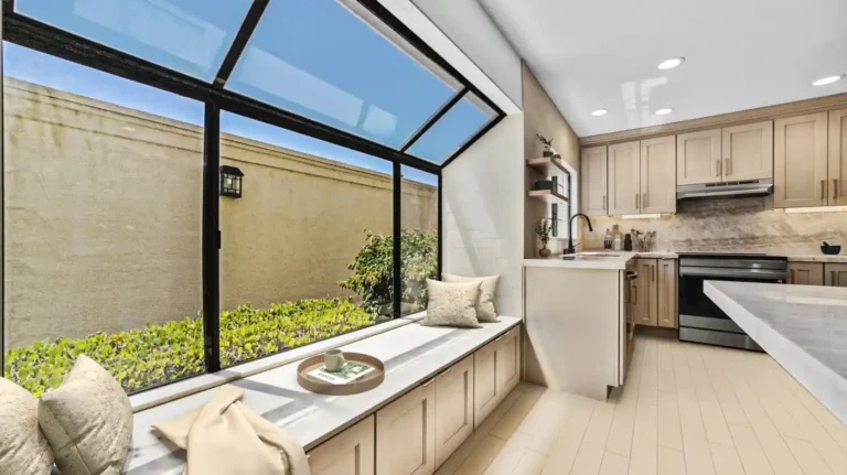 Built-in window seat with storage beside the remodeled cooking area in a Carlsbad kitchen.