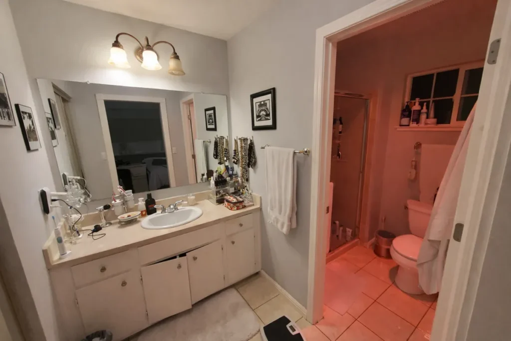 Yorba Linda guest bathroom before remodel with coral salmon walls, a dated cramped layout, and older vanity fixtures