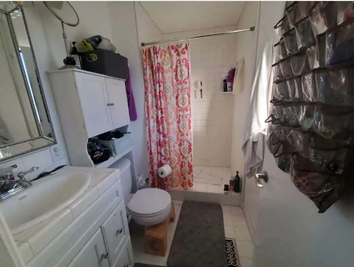 Fountain Valley guest bathroom before remodel with a cramped layout with pink tile and outdated fixtures