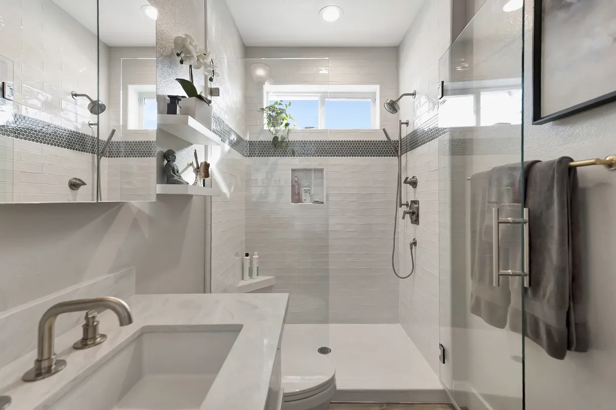 Fullerton master bathroom remodeling project — a frameless shower with white subway tile and mosaic accent band