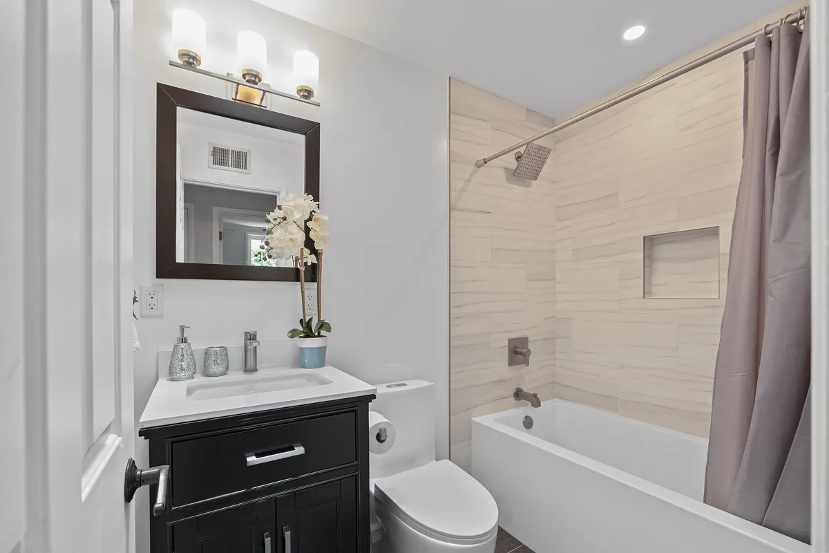 Villa Park guest bathroom remodeling project — a dark vanity and designer subway-tile tub surround