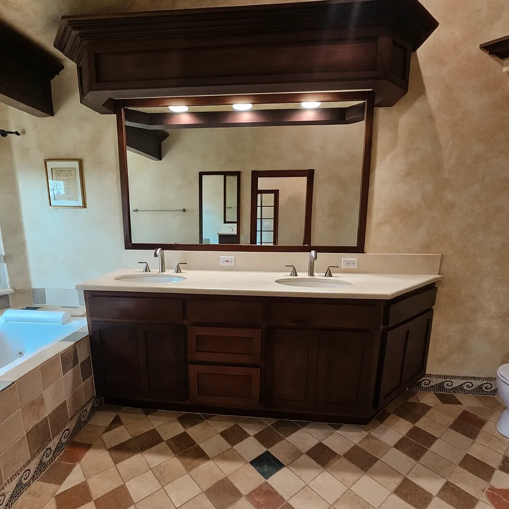 Fullerton master bathroom before remodel with a dark walnut double vanity, heavy traditional styling, and a dated mosaic floor