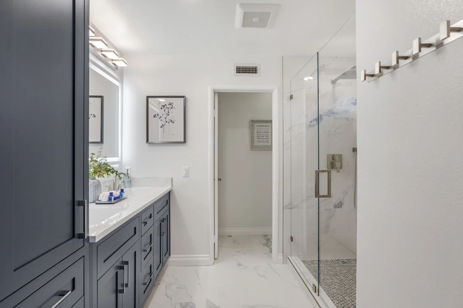 Walk-in shower and charcoal double-sink vanity in a finished bathroom remodel in Irvine, California