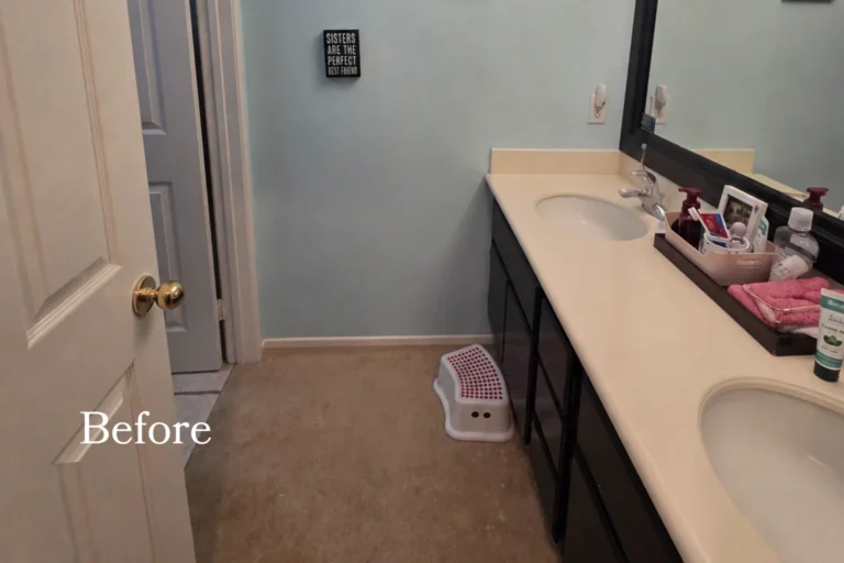 Before photo of a dated Placentia bathroom with a dark double vanity, black-framed mirror, blue walls, and carpet flooring