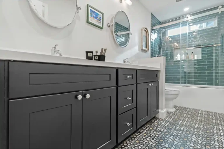 Charcoal shaker vanity cabinets and patterned blue mosaic floor tile in a remodeled Anaheim guest bathroom.
