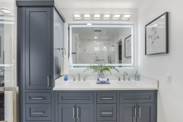 Backlit LED mirror above a charcoal double-sink vanity in a remodeled bathroom in Irvine, California