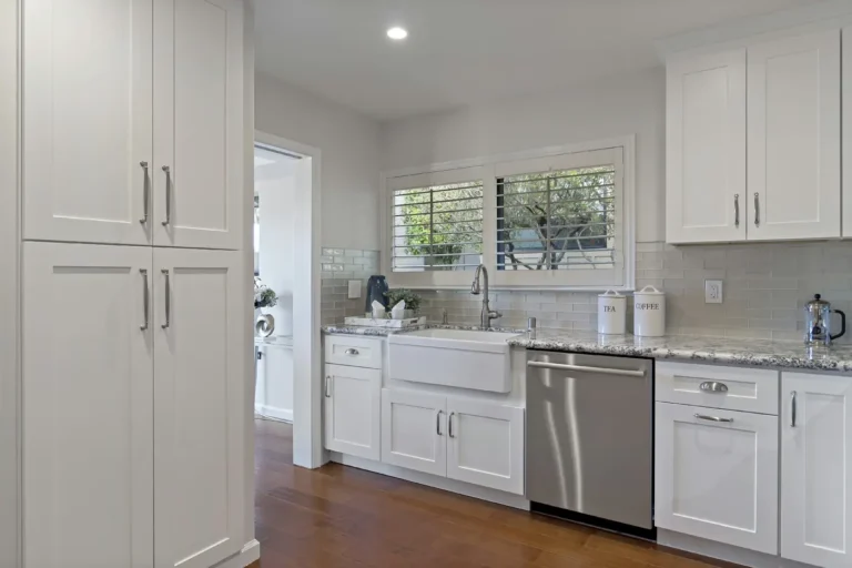 Floor to ceiling pantry cabinets stand beside the sink wall in this Laguna Hills kitchen remodel