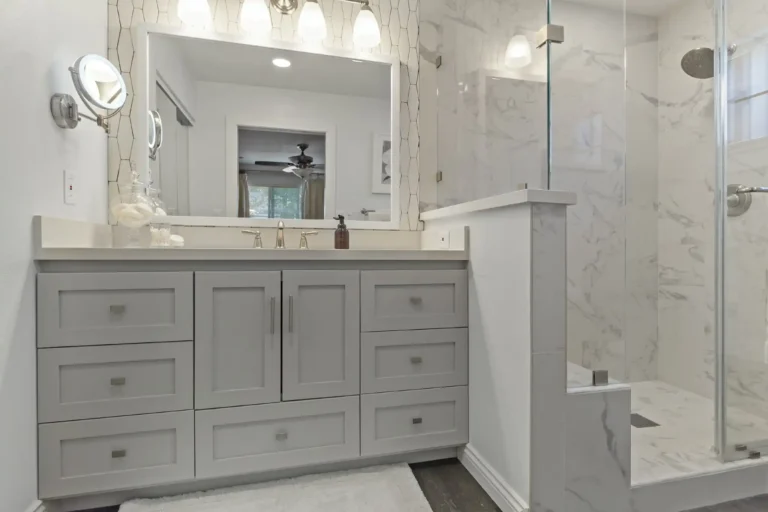 Mission Viejo bathroom vanity with large framed mirror beside a glass walk‑in shower.