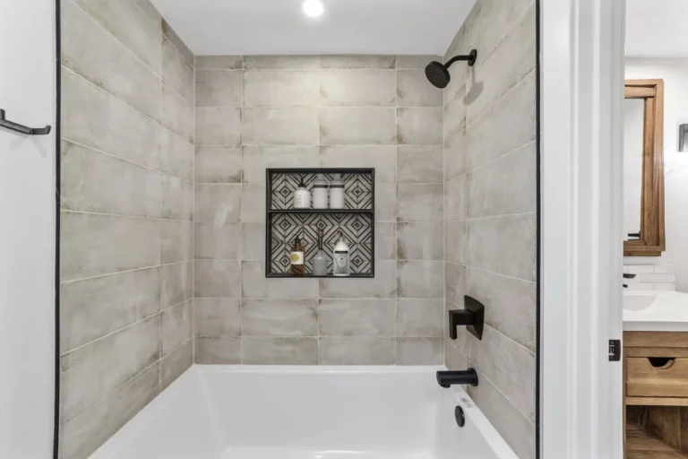 Large-format tile tub and shower surround with a patterned storage niche in a Santa Ana bathroom remodel