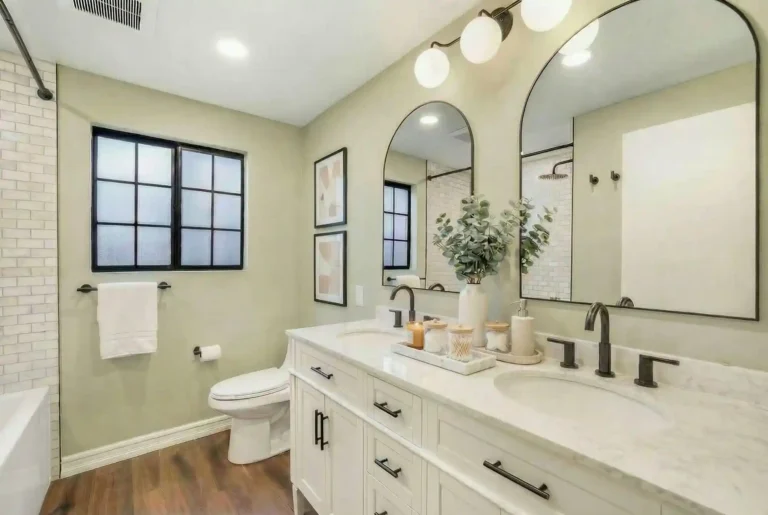 Irvine bathroom remodel with a white shaker vanity, marble countertop, modern black fixtures, and a subway tile shower in neutral tones.
