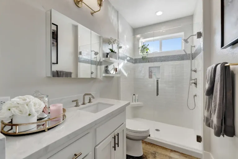 Marble-look quartz countertop beside a tiled walk-in shower in a Newport Beach master bathroom