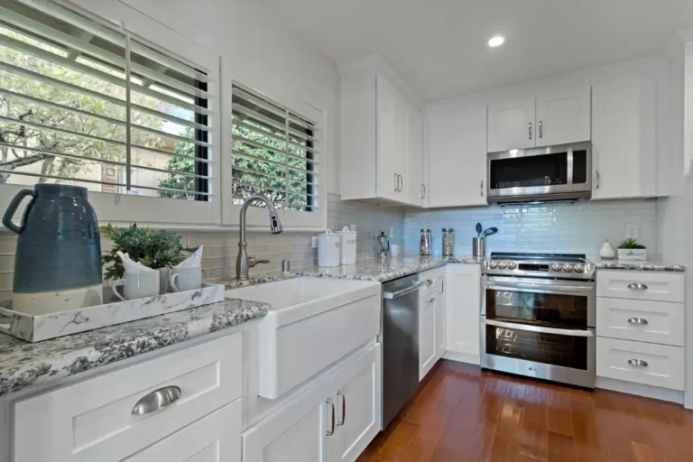 Speckled granite countertops and a glossy subway tile backsplash line the range wall of a Laguna Hills kitchen remodel