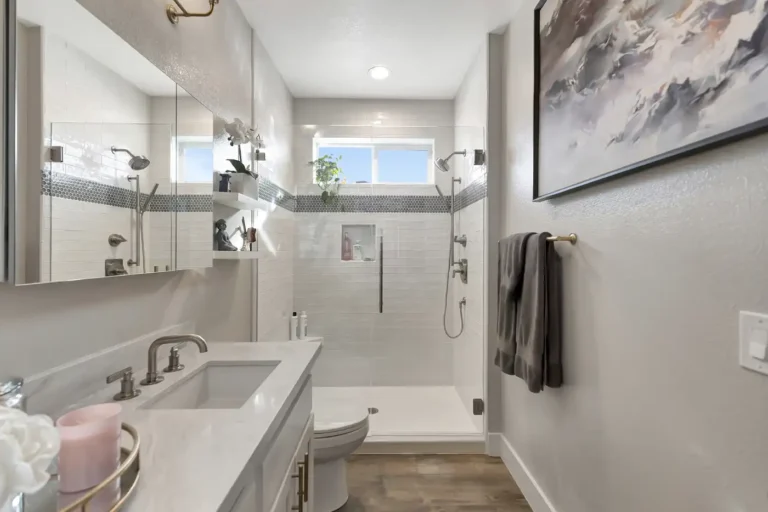 Walk-in shower with a wall-mount head and handheld sprayer in a Newport Beach master bathroom