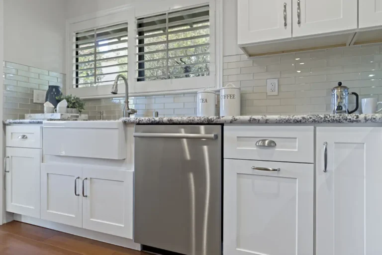 Apron front sink set into granite countertops with a stainless dishwasher in a Laguna Hills kitchen remodel