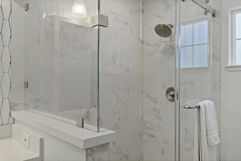 Porcelain marble‑look walk‑in shower in Mission Viejo with rain showerhead and clear glass.