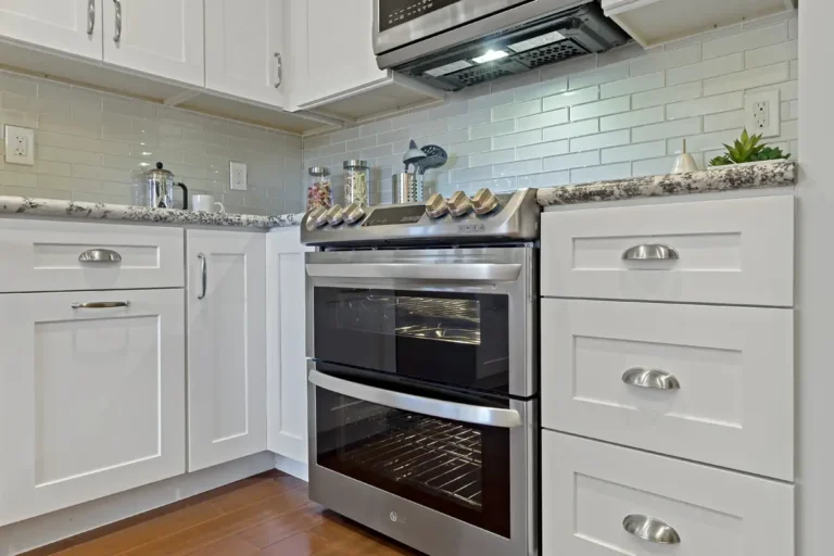 Stainless steel double oven range flanked by deep drawers with cup pulls in a Laguna Hills kitchen remodel
