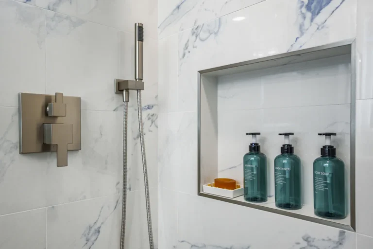 Brushed nickel shower valve and recessed shampoo niche in a bathroom remodel in Irvine, California