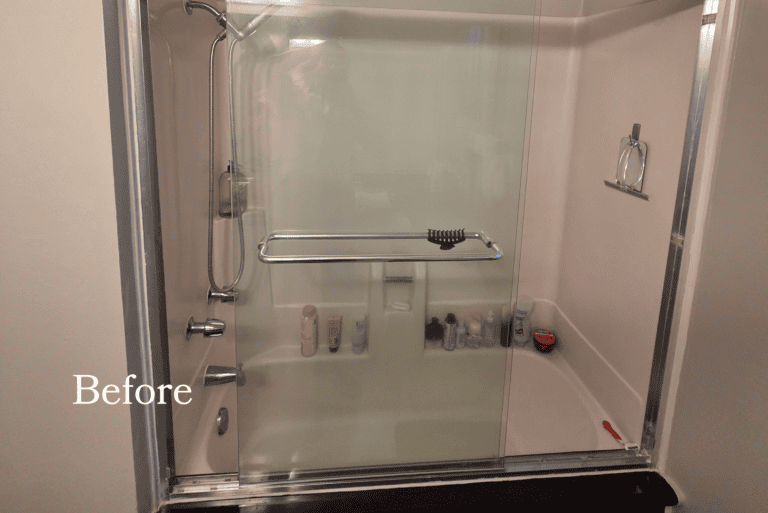 Before photo of a bathroom tub-shower combo with sliding glass doors, chrome fixtures, and a standard fiberglass surround prior to remodeling.