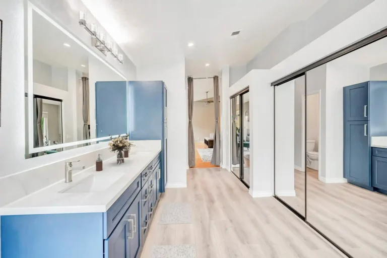Mirrored closet doors and a long blue vanity in a remodeled Laguna Hills primary bathroom.
