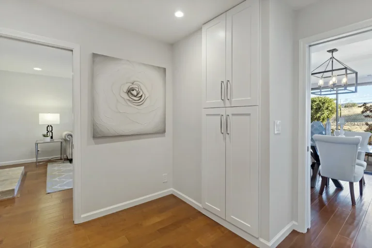 Tall white storage cabinets in the hallway between the dining room and living room of a Laguna Hills remodel