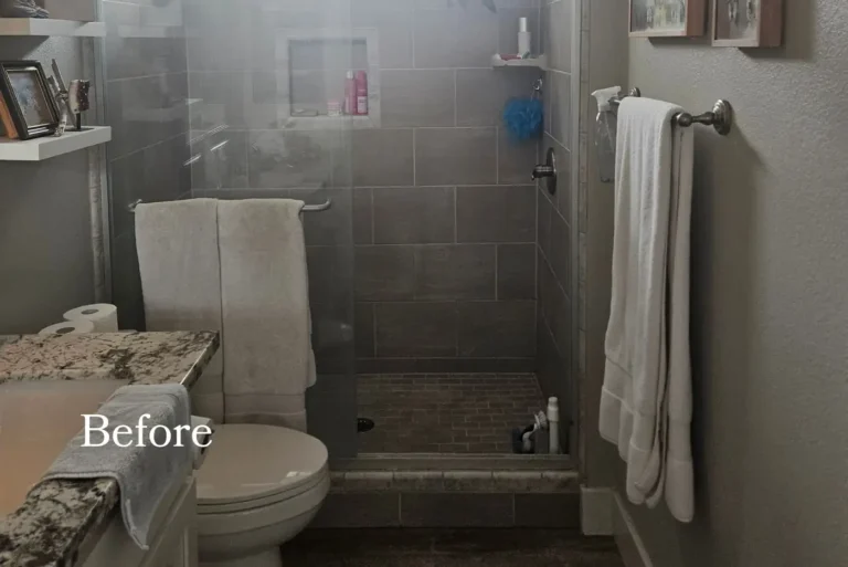 Before photo of a dated Newport Beach master bathroom with dark gray tile and a cramped corner shower