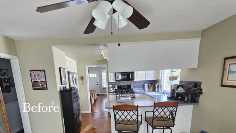 Before photo of a dated Irvine kitchen with a closed soffit, speckled gray countertops, dark tile, and a ceiling fan.