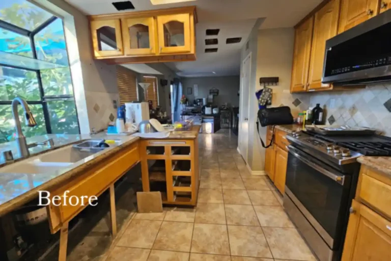 Oceanside galley kitchen before remodeling, with honey oak cabinets, granite counters, and beige tile floors