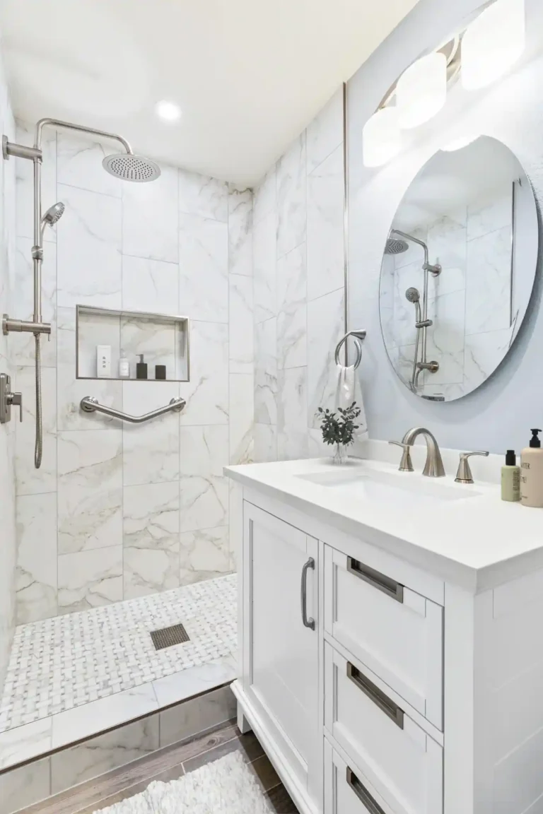 Marble-look tile wall and recessed black-framed shelving behind a white vanity in a Mission Viejo bathroom